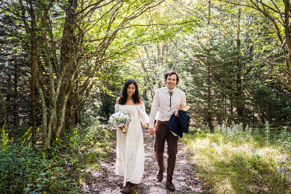 Two marriers walk hand-in-hand on the Twin Pinnacles trail for their Grayson Highlands State Park elopement.