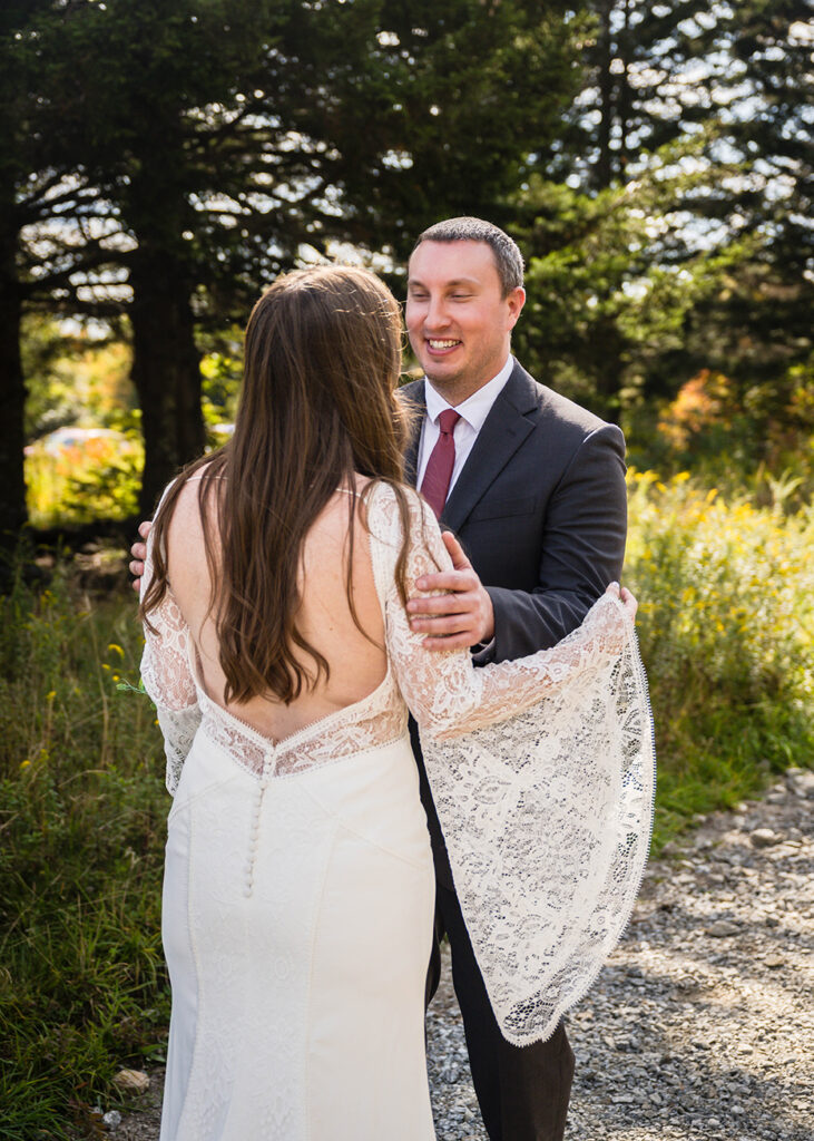 A groom reacts warmly to seeing his bride in a wedding dress and goes to embrace her.