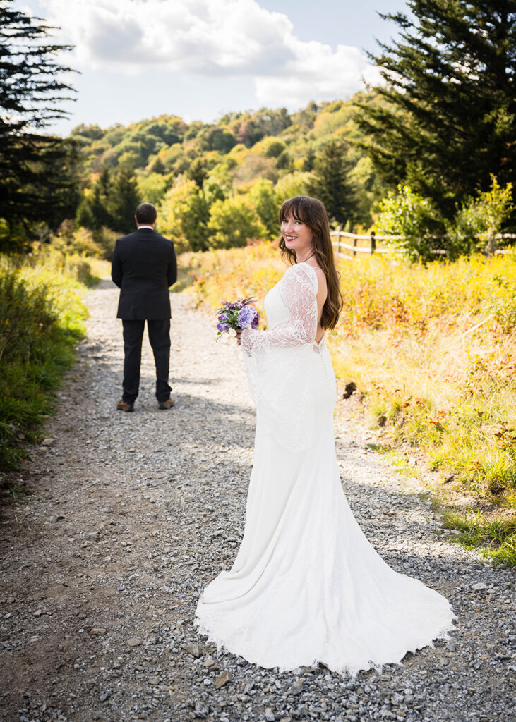 A wedding couple gets ready for their first look on a walking trail in Grayson Highlands State Park.