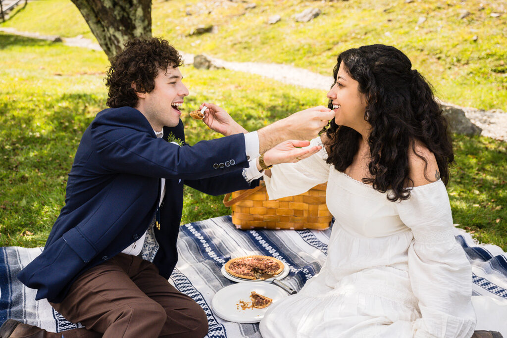 Two marriers feed each other a bite of pecan pie.