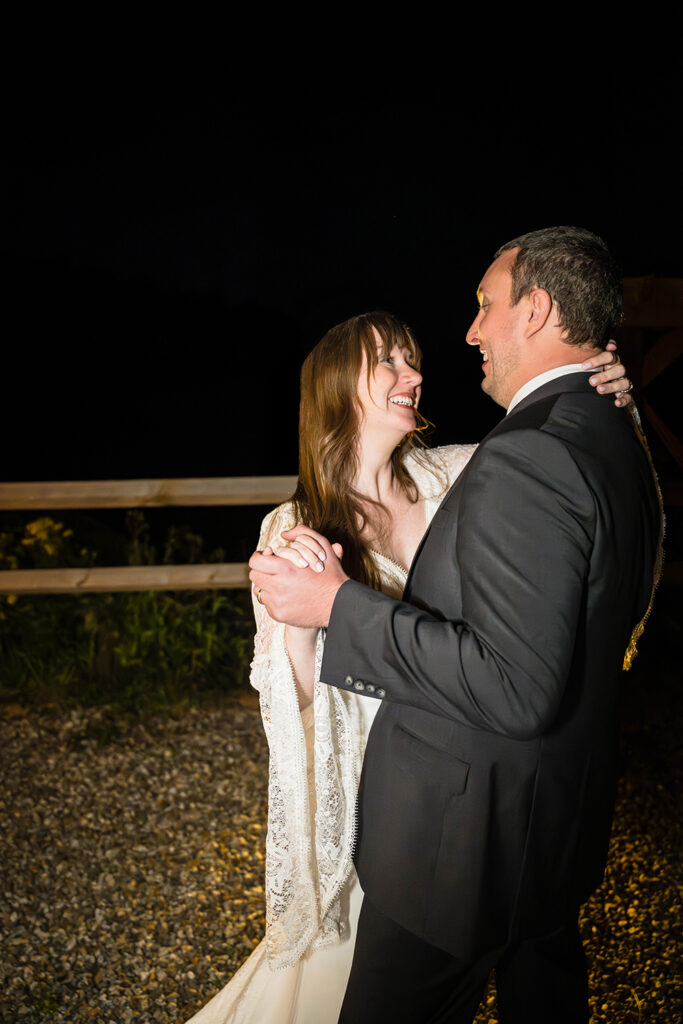 A wedding couple on their elopement day has their first dance outside of their Vrbo at Highland Hideaways under the night sky.