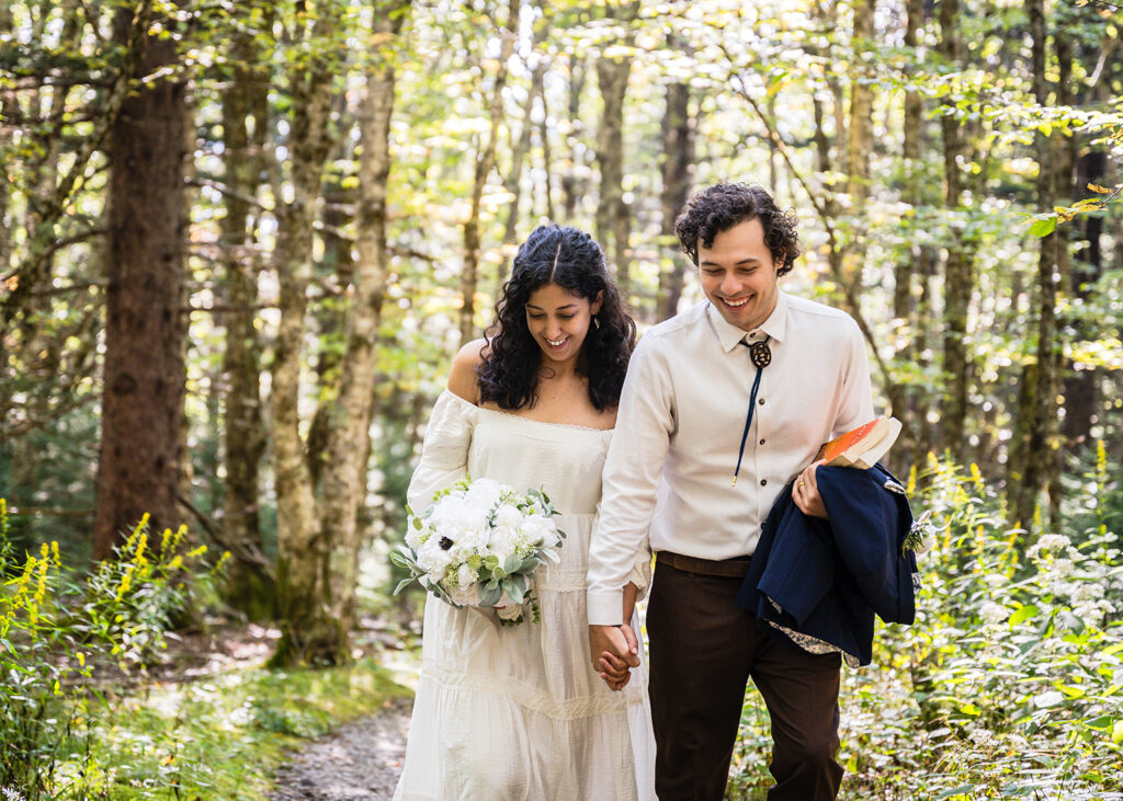 A bride and groom walk hand-in-hand on the Little Pinnacle trail for their Grayson Highlands State Park elopement.