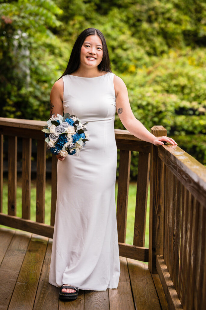 A queer marrier stands outside of an Airbnb for a portrait.