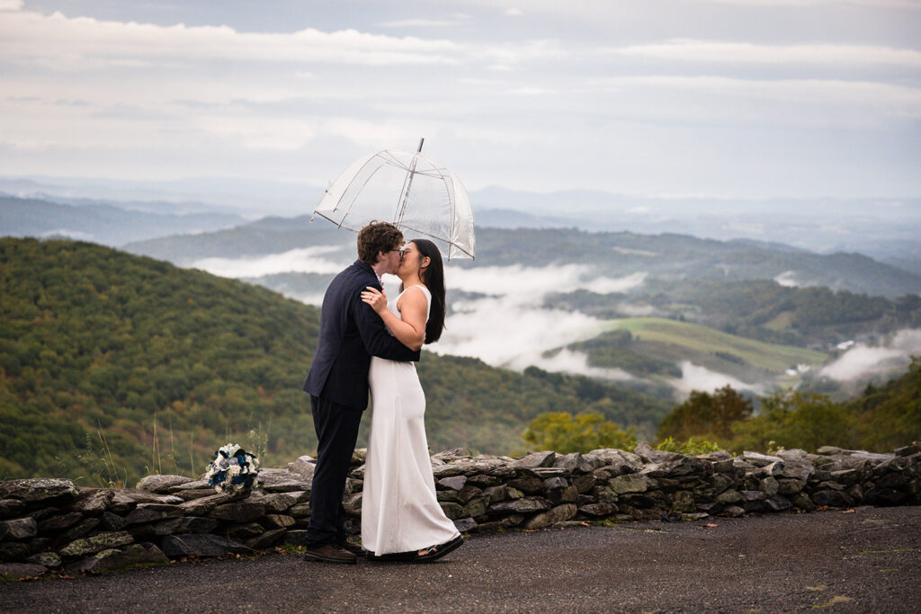 An elopement couple goes in for their first kiss during their ceremony at Sugarland Overlook.
