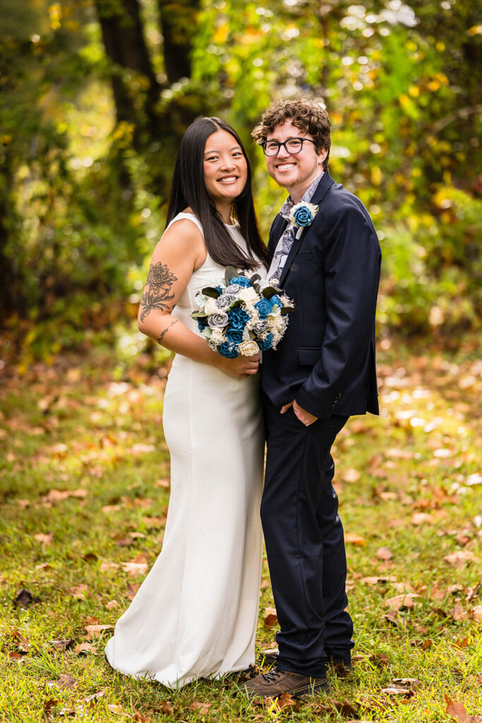 A queer elopement couple stands together for a formal portrait on their wedding day.