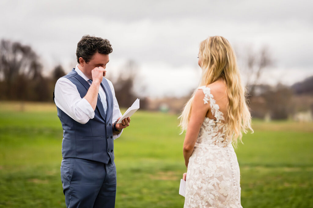 A groom tears up as he reads his wedding vows.